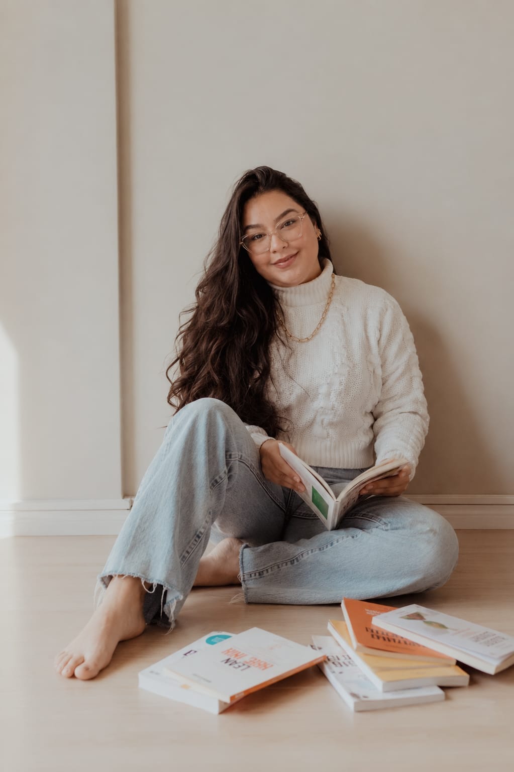 Ana Paula lendo, cercada por livros de psicologia